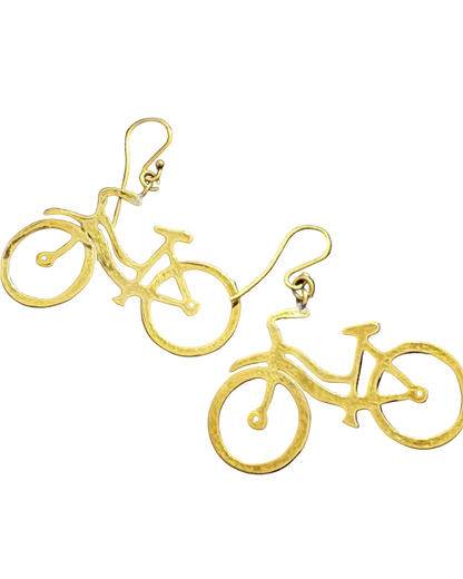 A pair of gold bicycle-shaped dangle earrings on a textured black fabric background.