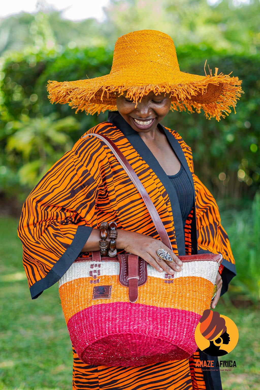 Model wearing a woven hat and carrying a bright sisal and leather tote
