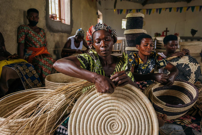 Women artisans working together on woven baskets