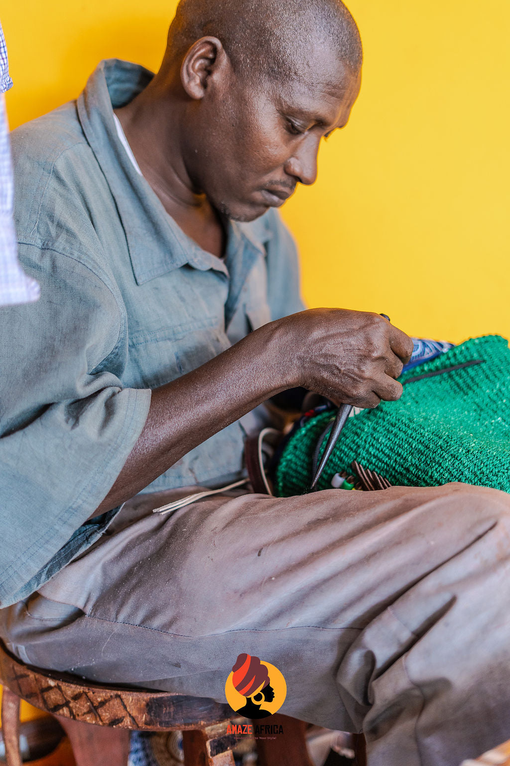 Artist finishing a green woven bag by hand